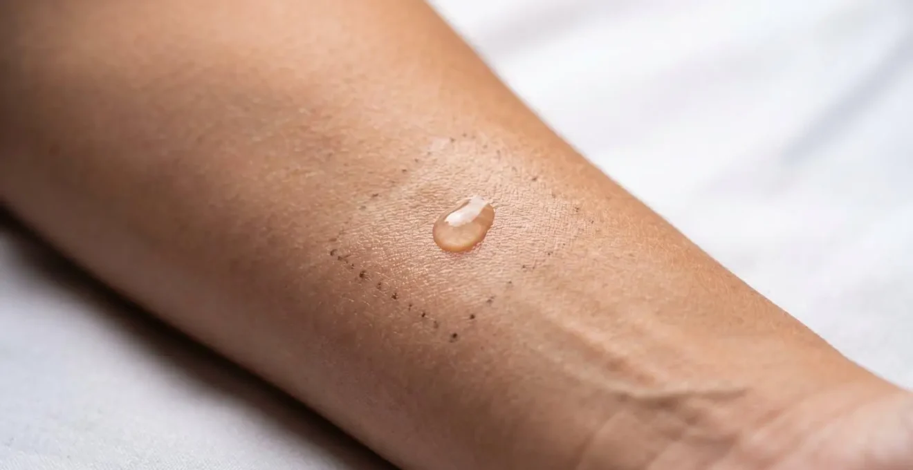 Primer plano de antebrazo con pequeña prueba de producto cosmético aplicada en zona delimitada